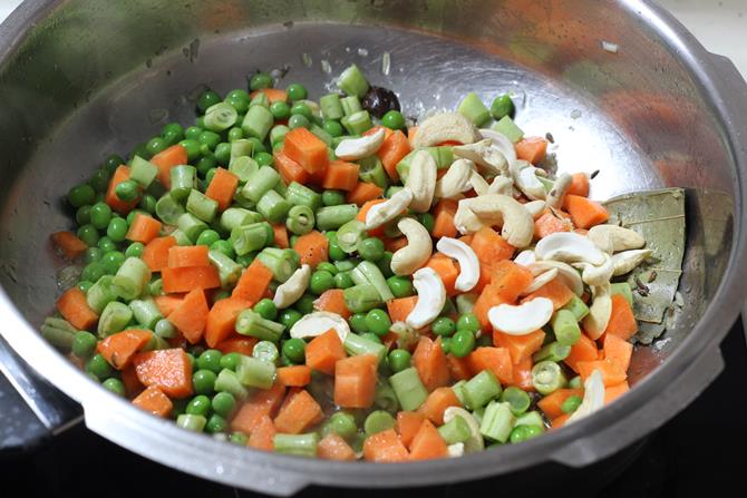 adding chopped veggies to pan for veg pulao