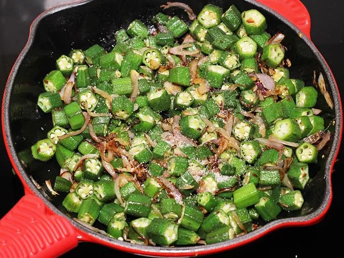 sprinkling salt over bhindi to make sabji