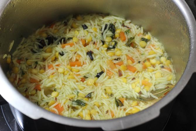 cooking chana dal pulao on a medium flame