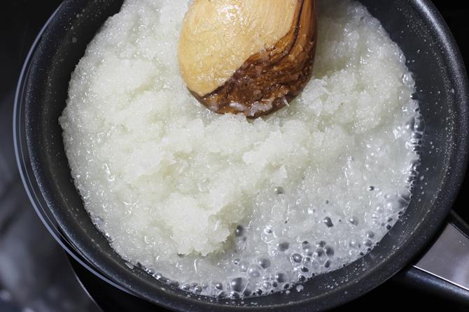 gooey bubbling mixture in coconut barfi
