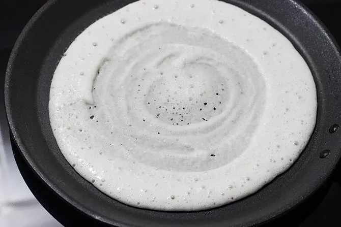 spread dosa batter on a pan