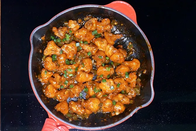 Garnish gobi manchurian with spring onions