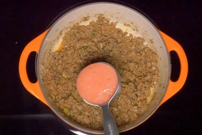 adding tomato puree to make keema