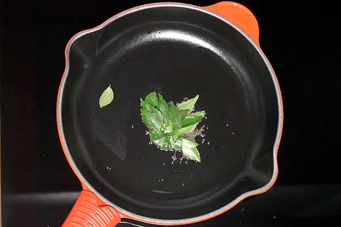 adding curry leaves to make batata vada stuffing