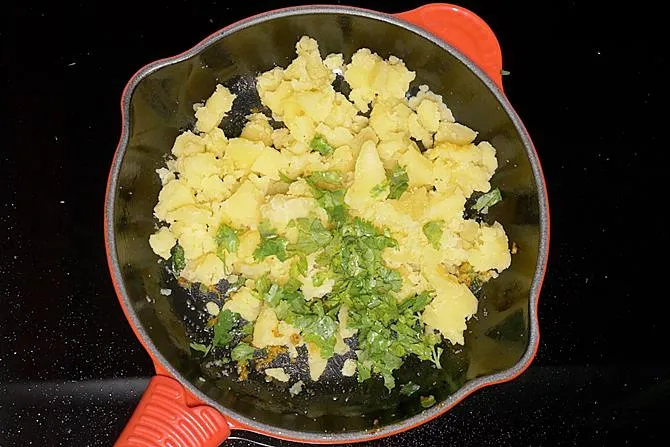 adding coriander leaves to make batata vada stuffing