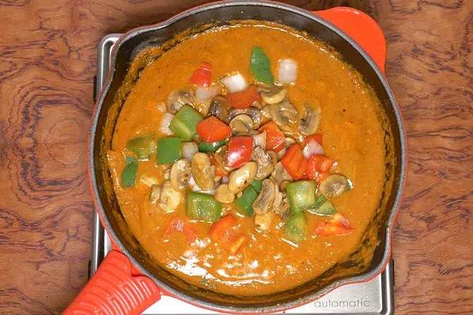 adding veggies to make kadai mushroom recipe