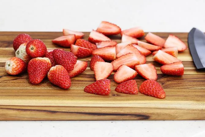 sliced strawberries on a chopping board