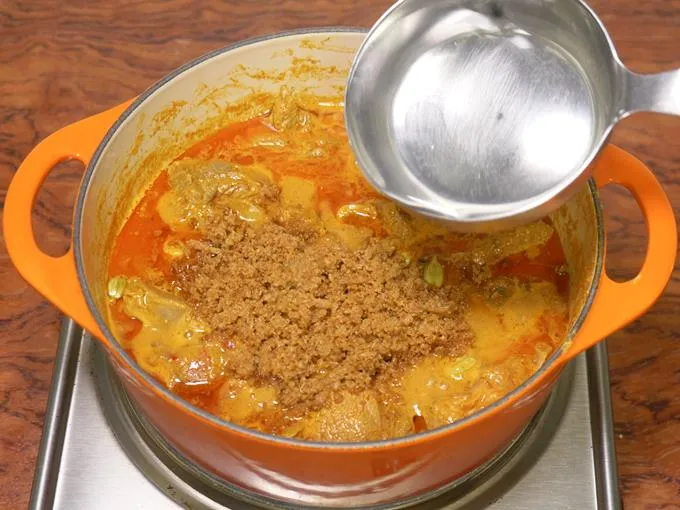 pouring water to cook mutton korma