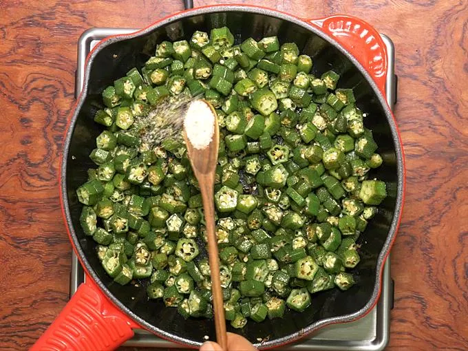 adding salt to make bhindi fry