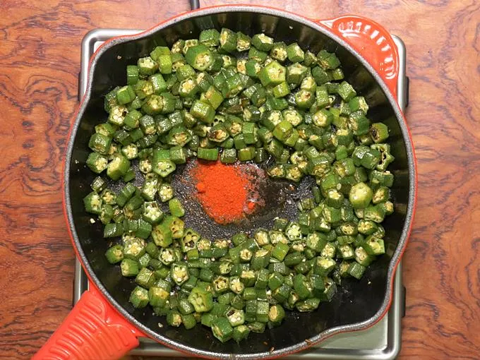 adding spice powder to make bhindi fry