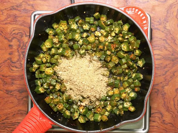 adding nut powder to make bhindi fry