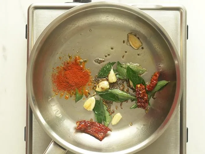 adding garlic red chilies to make tomato dal