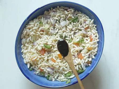 adding tamarind chutney to bhel puri