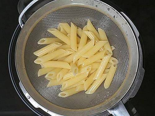 al dente cooked pasta in colander