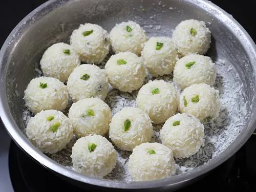 rolling coconut laddu in coconut