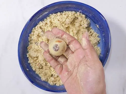 pressing down the mixture to make rava ladoo