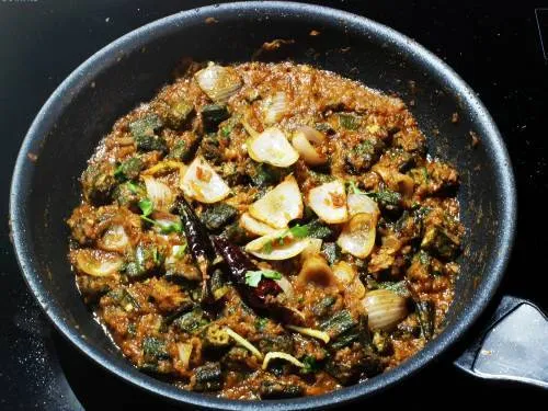 adding tempering to cooked bhindi do pyaza