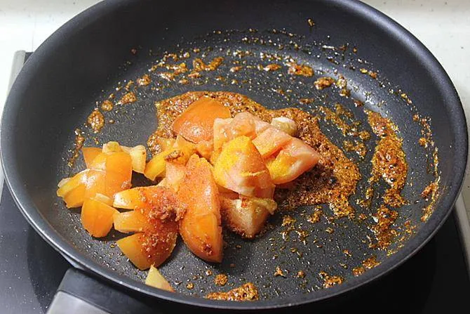 sauteing tomatoes in pan for kadai mushroom