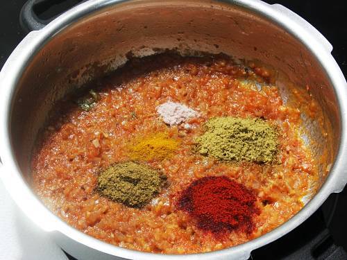 aggiungere le polveri di spezie per fare il masala di pomodoro alla cipolla