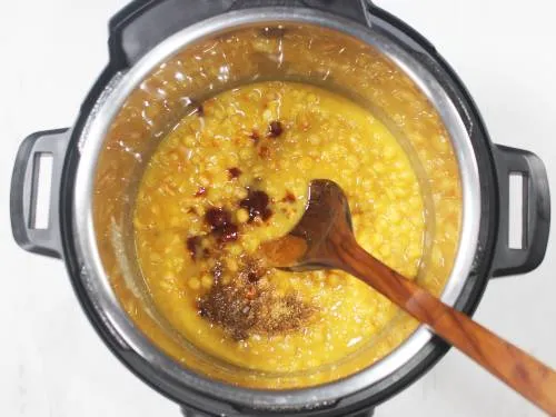 Adding tamarind spices to pressure cooked ragda