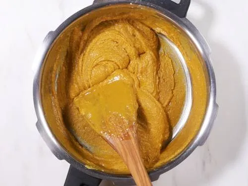 mixing besan with sugar syrup