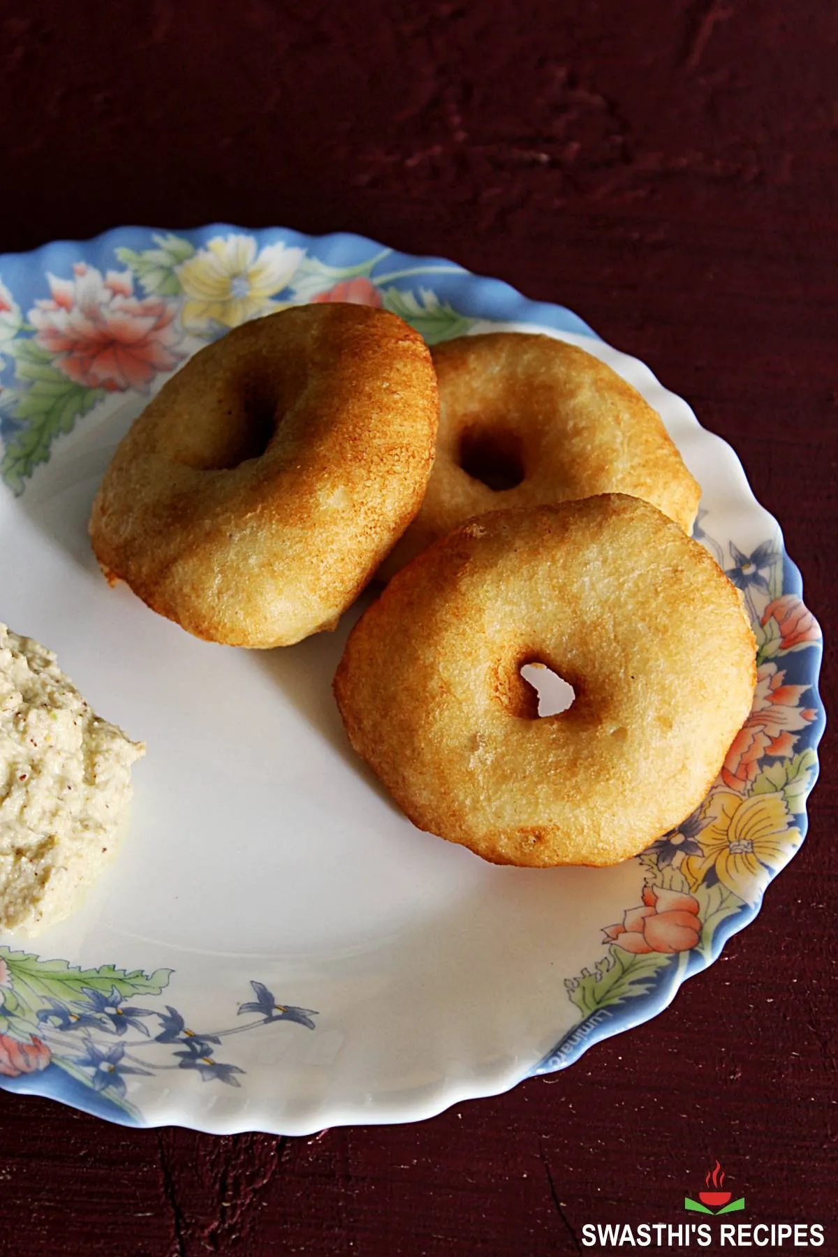 medu vada served with coconut chutney in a white plate