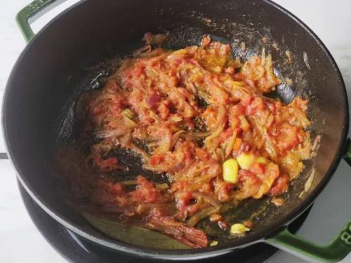 sautéed onions and tomatoes in a pan
