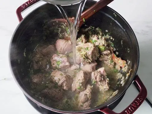 pouring water to cook mutton