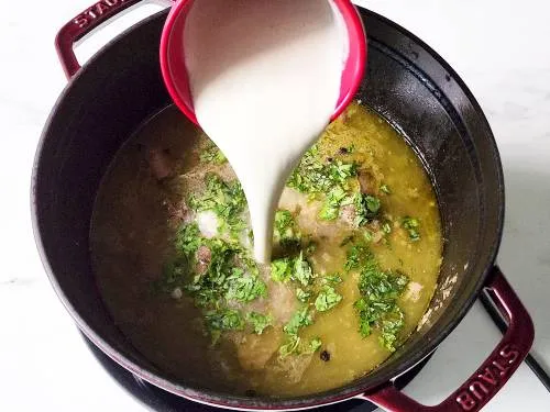 adding nut paste, mint and coriander to the marag