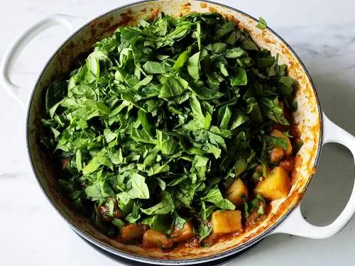 spinach in a pan to make aloo saag