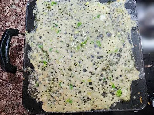 pouring jowar dosa batter on a pan