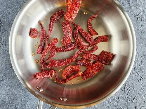 roasting red chilies in a pan